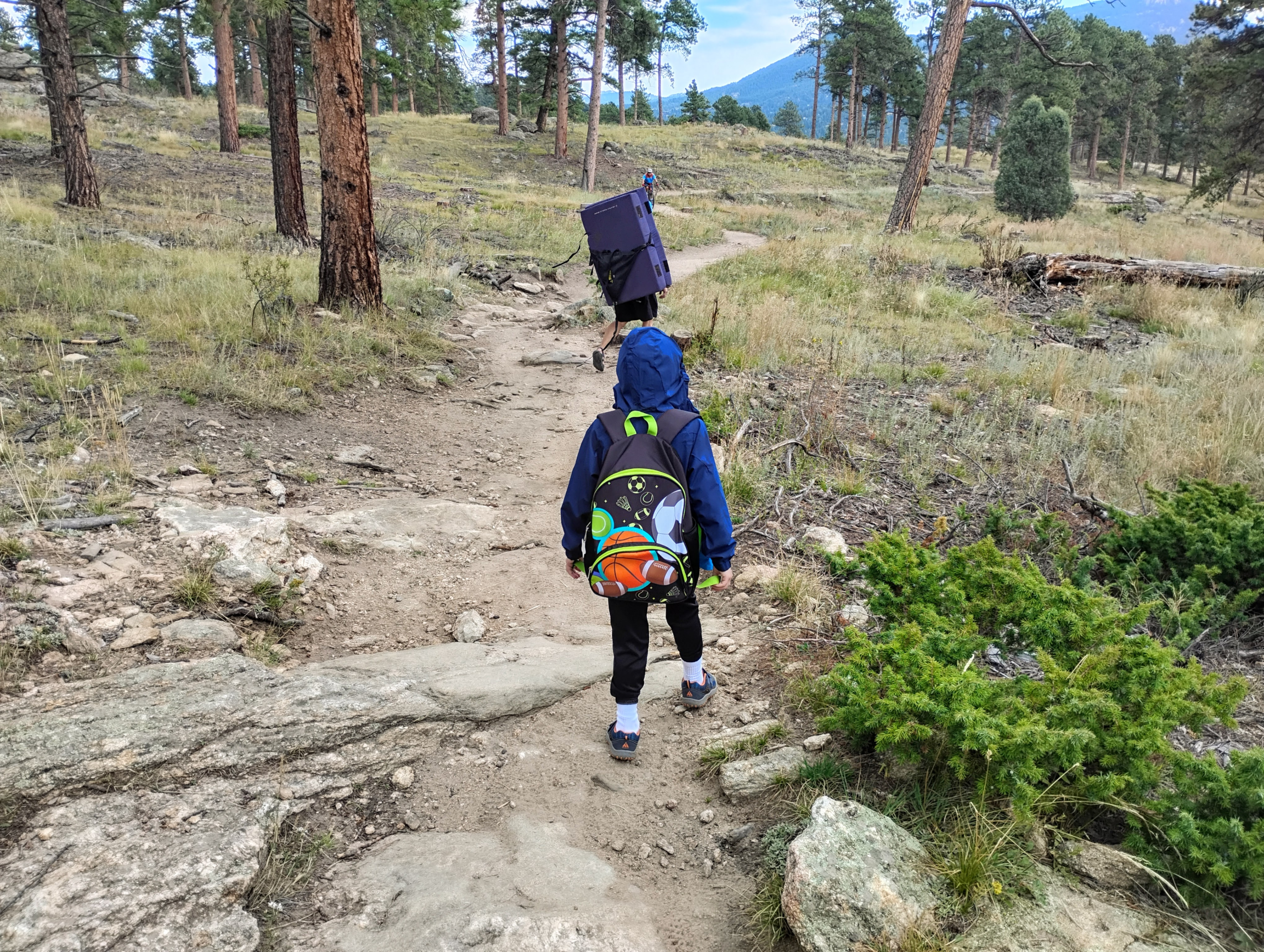Kid and adult walking with bouldering pads